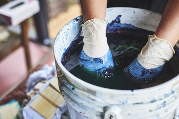 a woman dying fabric with indigo dye.