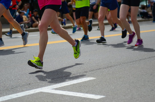 Marathon running race, many runners feet on road, sport, fitness and healthy lifestyle concept
