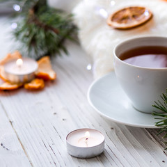 Winter breakfast. Tangerine and a cup of tea. Tree and the candles on the windowsill. Christmas morning 