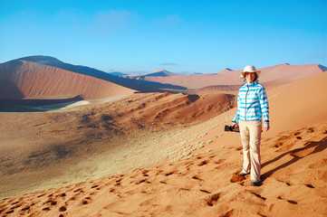 African vacation holiday, woman tourist travels Namib desert dunes and lanscape, Namibia, Africa
