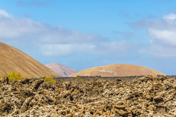 Landscape of Timanfaya National Park in Lanzarote, Canary Islands, Spain. Red and black volcanic...