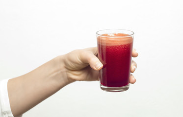 A glass of fresh juice in a hand.