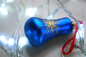 Blue christmas ornament surrounded by garland in cold tones.