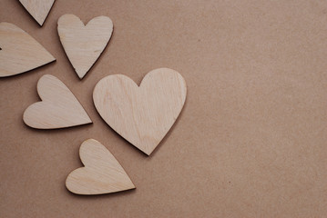 Valentines day background with Laser Cut Wooden Hearts on Neutral Craft Paper Background with Copy Paste. Rustic Love Background.