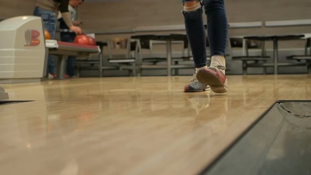 Woman in club for bowling is throwing ball
