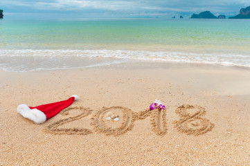 New year 2018 holiday vacation concept, 2018 written on tropical beach sand background
