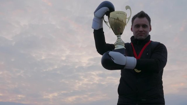 Happy boxer with winner cup and gold meral