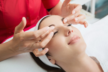 Obraz na płótnie Canvas Face massage. Close-up of young woman getting spa massage treatment at beauty spa salon.