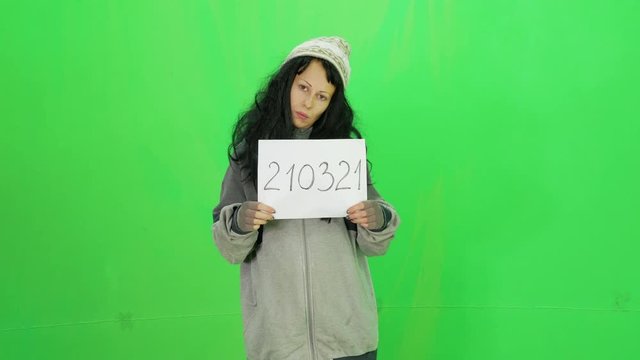 Hobo woman with number in the police jail green-screen shot