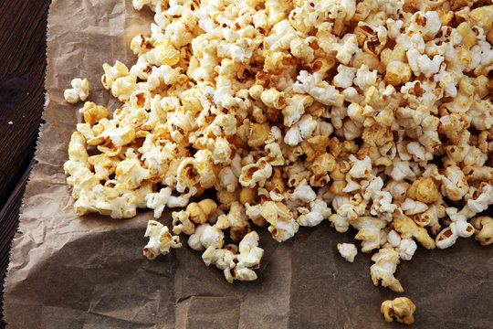 many popcorn on brown paper on wooden background