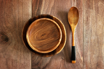 Wooden Plate, Bowl, and Spoon Dinnerware on Rustic Cherry Plank Table