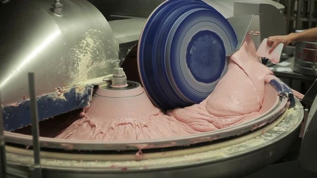 Minced meat production machine mixing meat and spices for making sausages in a food factory