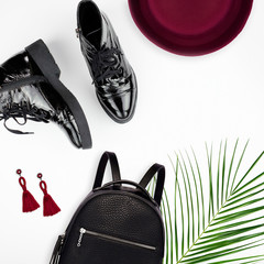 Top view of a backpack, shoes, earrings, hat. Isolated