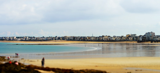 Yellow sandy beach miniature tilt-shift view while low tide water