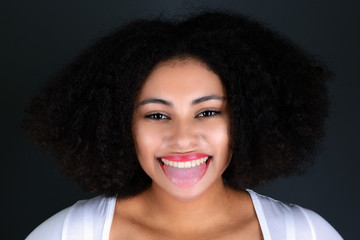 Young black woman with afro hairstyle smiling. 