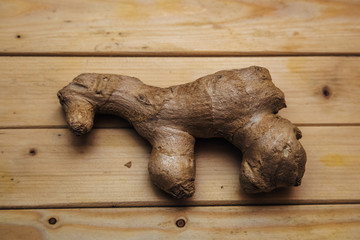 Root of ginger in the form of a horse on wooden background