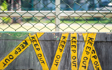 Keep out sign on stone in front of soccer field. Drawing concept.