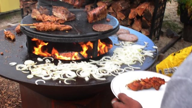 garden barbecue picking a piece of Livar pork roast for cutting