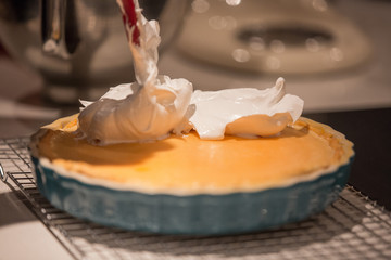 Meringue being applied to a lemon tart 