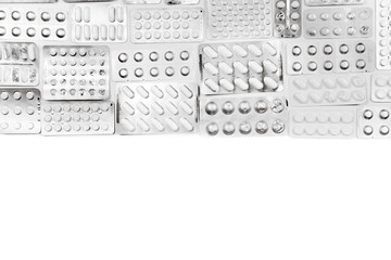 Tablets, capsules and medicine in packs. View from above. White background. Black and white photo.