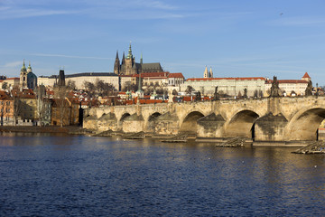 Fototapeta na wymiar View on the winter Prague gothic Castle with the Charles Bridge in the sunny Day, Czech Republic