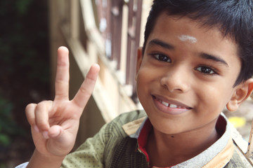 Portrait of Indian Boy showing victory or peace sign