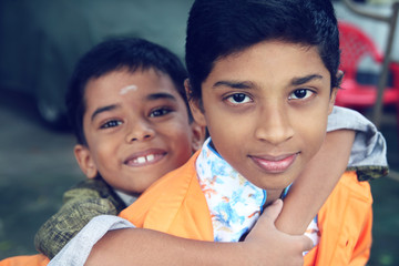 Indian Boy carrying his brother with expression