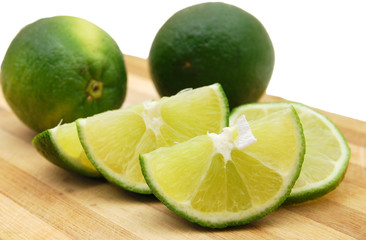 Fresh organic cut limes on wooden cutting board