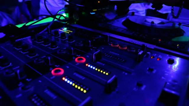DJ Spinning, Mixing and Scratching in a Night Club, Hands of DJ tweak various track controls on dj's deck, camera is breathing, September 14, 2017. United States of America, USA