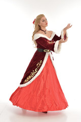 full length portrait of pretty blonde lady wearing red and white christmas inspired costume gown,...