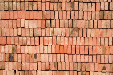 stacking red bricks as construction material background