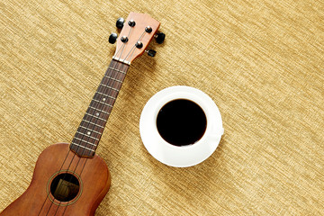 Top view with ukulele on the floor There are cup of coffee is placed