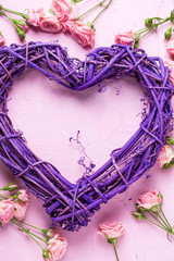 Violet heart and pink roses flowers on  pink textured background.