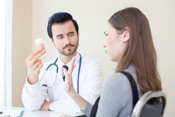 Obraz premium Doctor holding medicine showing to patient. People with medical concept.