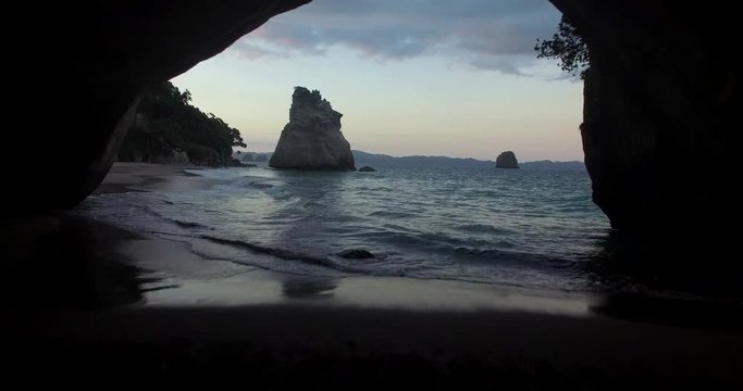 NEW ZEALAND – MARCH 2016 : Aerial shot from cave flying over Cathedral Cove Beach at sunset with beautiful landscape in view