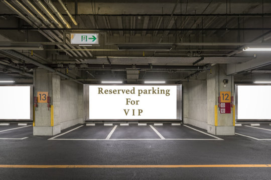Parking garage underground interior with reserved parking apaces sign board