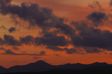 Sunset and sunrise. Orange and red colors. rock area. Volcanic area in Lanzarote national park. Mountain silhouette