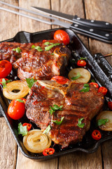Delicious T Bone steak with grilled vegetables on the grill pan close-up. vertical