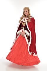 full length portrait of pretty blonde lady wearing red and white christmas inspired costume gown, standing pose on white background.