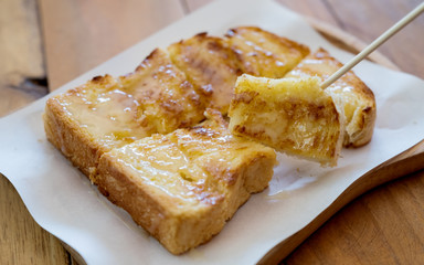 Closeup image of a piece of sliced bread toast with condensed milk