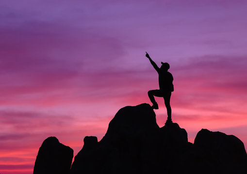 People climp up a mountain at sunset time. Giving forward, and active fit lifestyle concept.