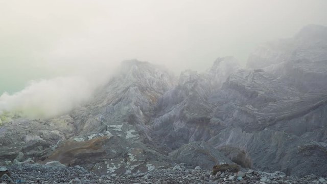 Extraction of sulfur in the crater of a volcano. Sulfur gas, smoke. Kawah Ijen, crater with acidic crater lake where sulfur is mined. Ijen volcano complex is a group of stratovolcanoes in the