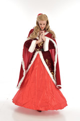 full length portrait of pretty blonde lady wearing red and white christmas inspired costume gown, standing pose on white background.