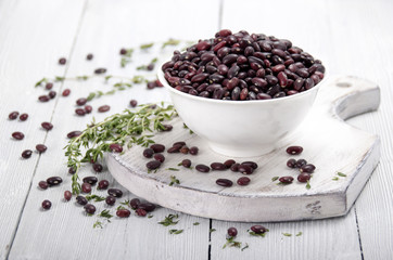 Red beans in a white cup on a white wooden table