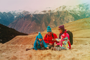 family with two kids travel in scenic winter mountains