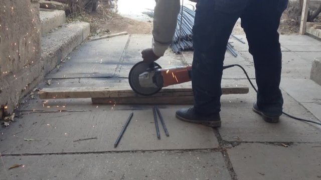 A blacksmith cutting iron bars outdoor for heavy construction work