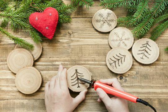 Christmas or New Year homemade pyrography toys. Wooden slice. Alternative decor. Xmas decorations. Child makes gifts for relatives. Top view.