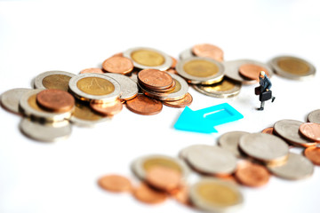 Miniature People : businessman walking between stack of coins
