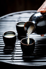 Closeup of delicious sake in black ceramics on black table