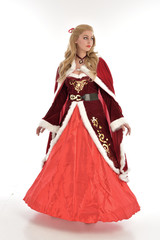 Fototapeta na wymiar full length portrait of pretty blonde lady wearing red and white christmas inspired costume gown, standing pose on white background.